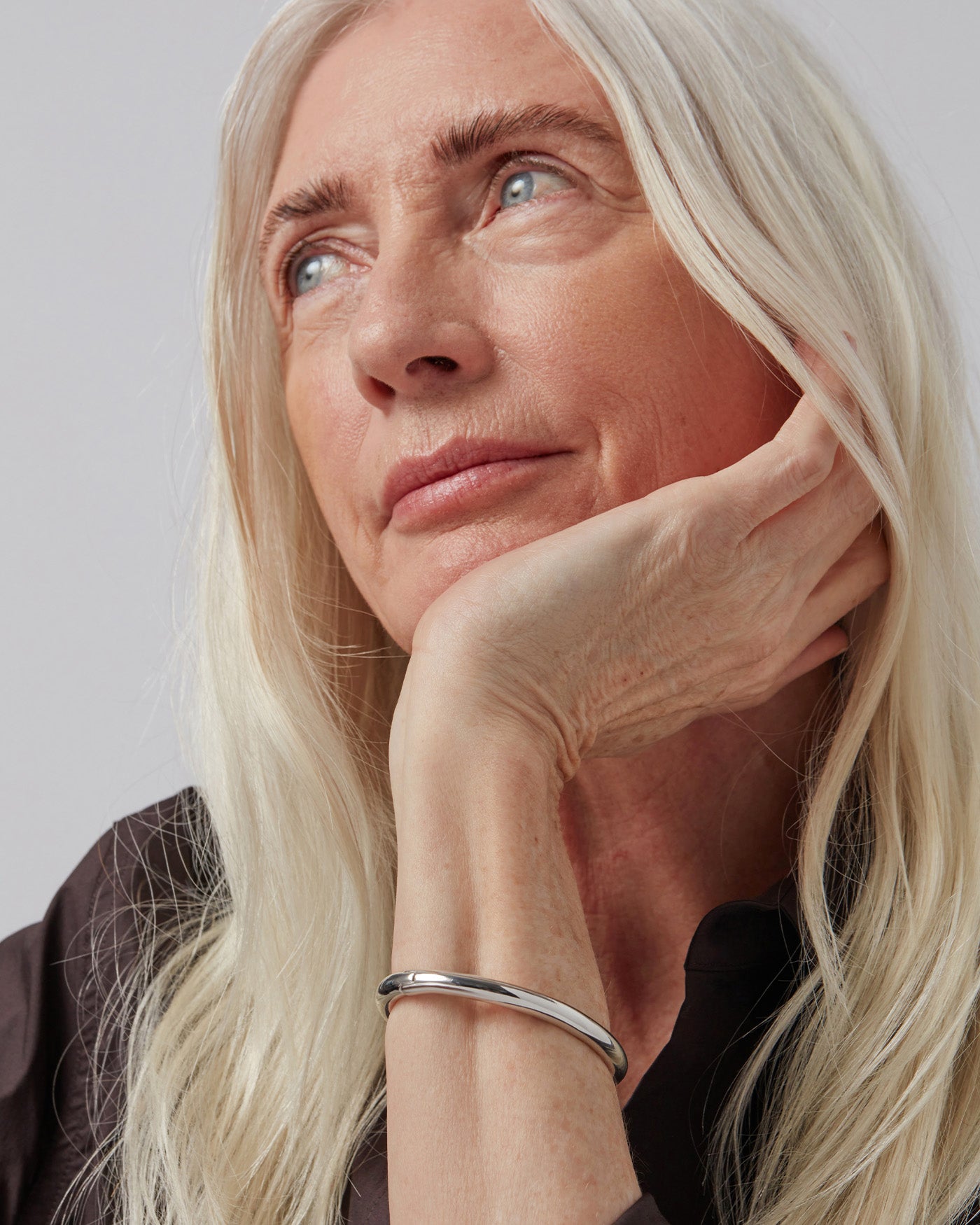 Woman wearing a large silver hoop earring with a close-up profile view.